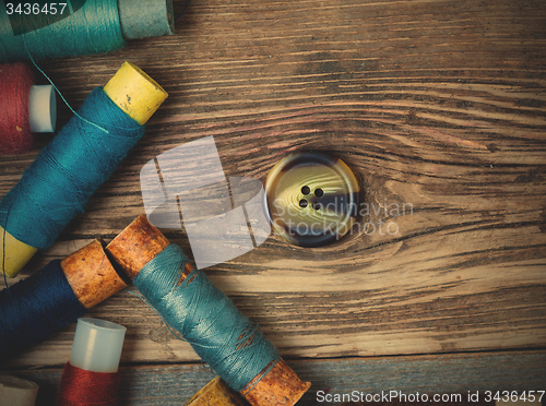 Image of old button and spools with threads