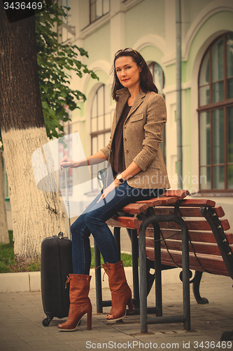 Image of beautiful adult woman with luggage on the platform