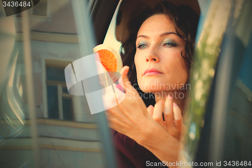 Image of pretty middle-aged woman checked the makeup