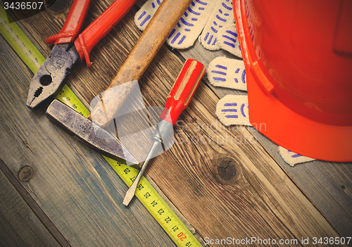 Image of Vintage hammer, pliers, screwdriver, tape measure, a bright helm