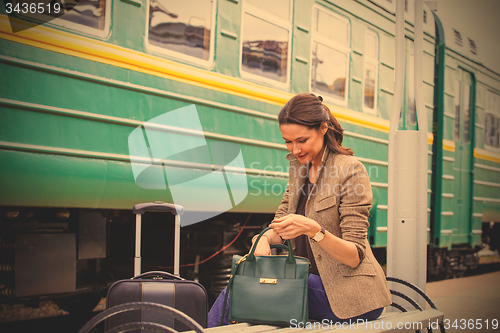 Image of beautiful woman rummages in a bag