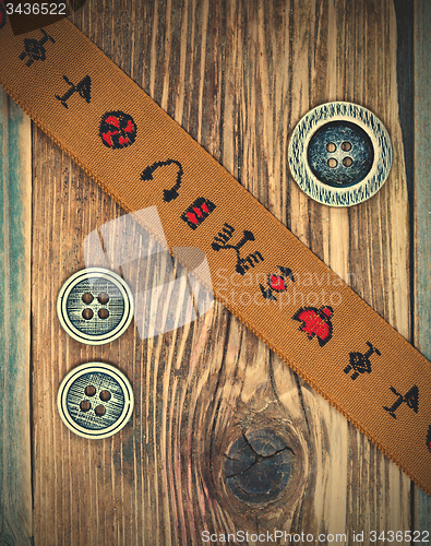 Image of vintage band with embroidered ornaments and old button