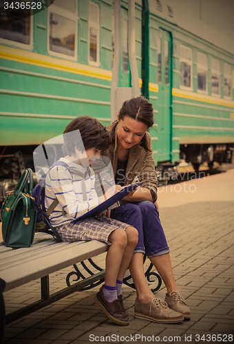 Image of beautiful woman and boy waiting train