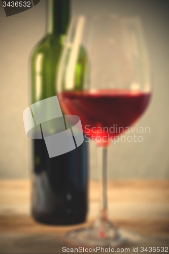 Image of red wine in goblet and green bottle