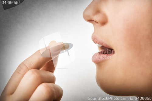 Image of closeup taking pill