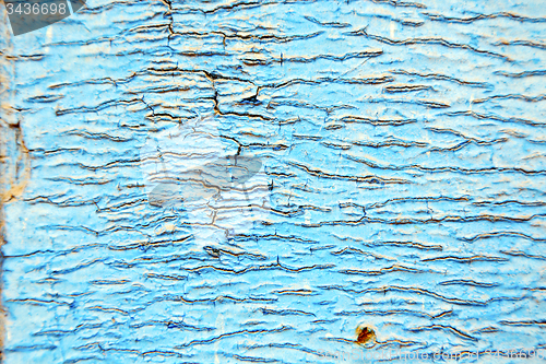Image of dirty stripped paint in the blue wood door  nail