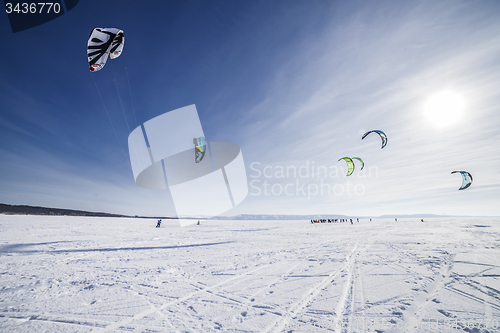 Image of Kiteboarder with blue kite on the snow