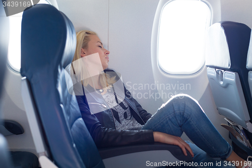 Image of Lady traveling napping on a plain.