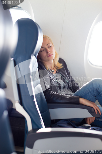 Image of Lady traveling napping on a plain.