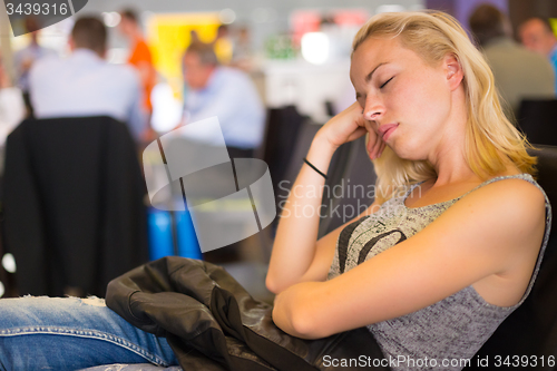Image of Tired female traveler waiting for departure.