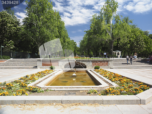Image of editorial tourists walk by the fountain entrance to Retiro Park 
