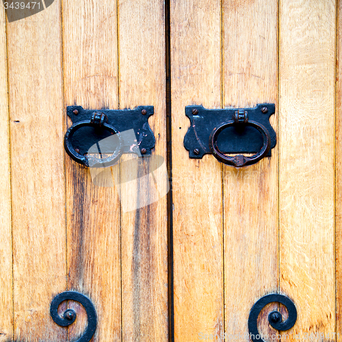 Image of handle in london antique brown door  rusty  brass nail and light