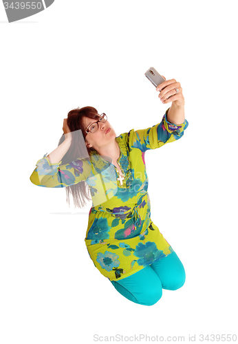 Image of Woman taking selfie kneeling.