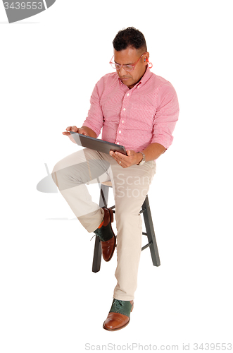 Image of Hispanic man sitting with tablet pc.