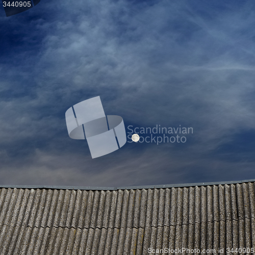 Image of tiled top of the roof and cloudy blue sky