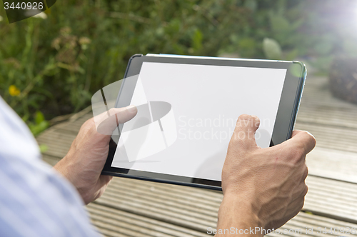 Image of Connectivity: Man using tablet outdoors