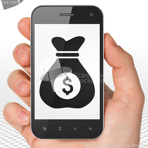 Image of Finance concept: Money Bag on Hand Holding Smartphone display
