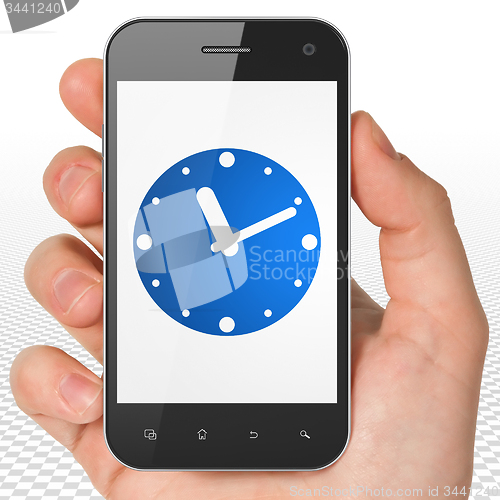 Image of Timeline concept: Hand Holding Smartphone with Clock on display