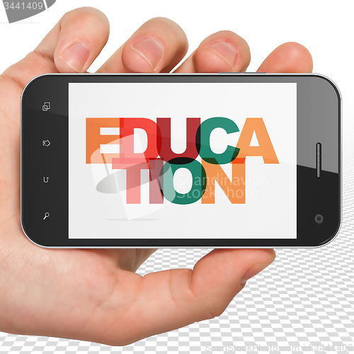 Image of Studying concept: Hand Holding Smartphone with Education on display