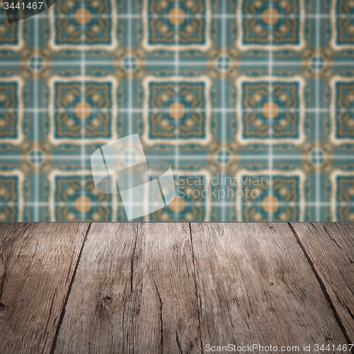 Image of Wood table top and blur vintage ceramic tile pattern wall