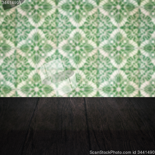 Image of Wood table top and blur vintage ceramic tile pattern wall