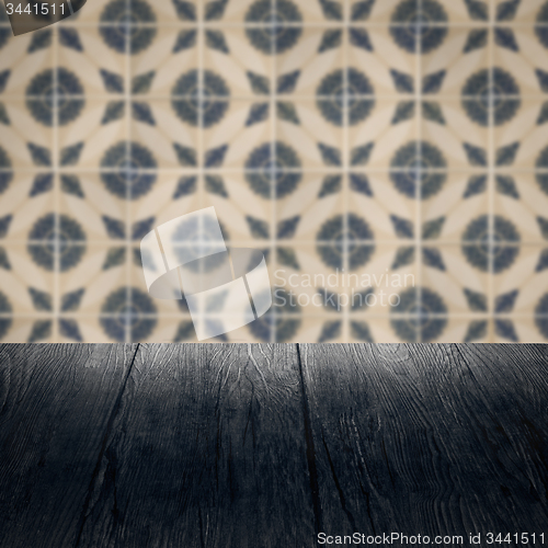 Image of Wood table top and blur vintage ceramic tile pattern wall