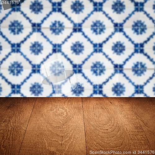 Image of Wood table top and blur vintage ceramic tile pattern wall