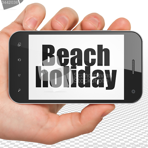 Image of Travel concept: Beach Holiday on Hand Holding Smartphone display