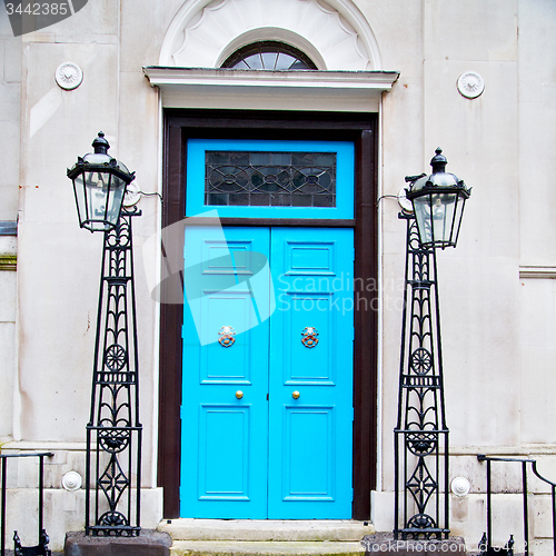 Image of  blue handle in london antique brown door  rusty  brass nail and