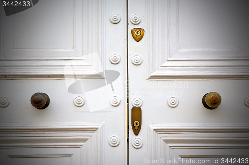 Image of handle in london antique brown door  rusty  brass nail and light