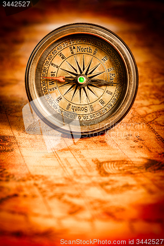 Image of Vintage compass lies on an ancient world map.