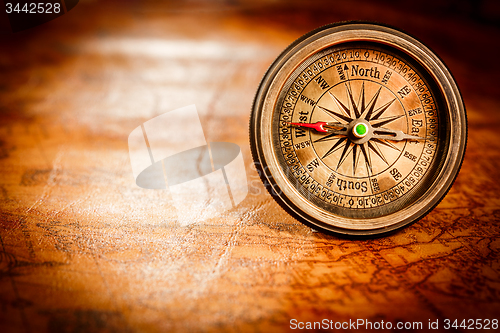 Image of Vintage compass lies on an ancient world map.