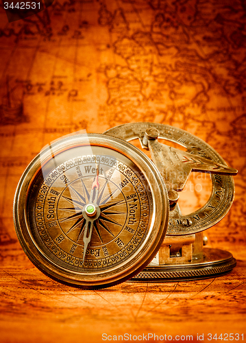 Image of Vintage compass lies on an ancient world map.