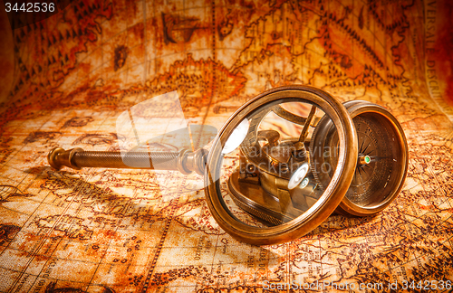 Image of Vintage magnifying glass lies on an ancient world map