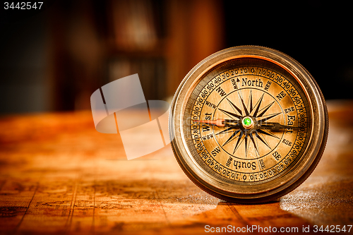 Image of Vintage compass lies on an ancient world map.