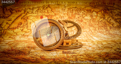 Image of Vintage compass lies on an ancient world map.