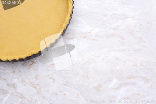 Image of Baking tin lined with pastry on worktop