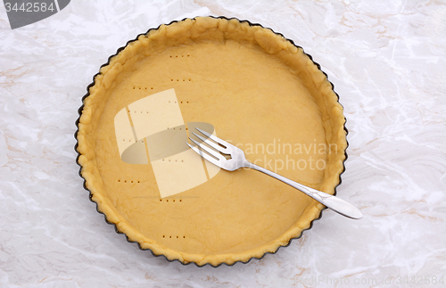 Image of Pricking shortcrust pastry case with a metal fork