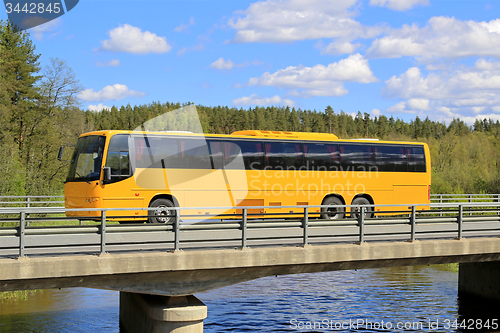 Image of Yellow Coach Bus on Scenic Bridge