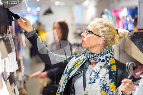 Image of Beautiful woman shopping in clothing store.