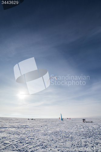 Image of Kiteboarder with blue kite on the snow