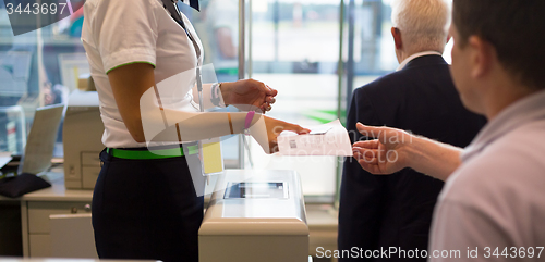 Image of Handing over air ticket at airline check in counter