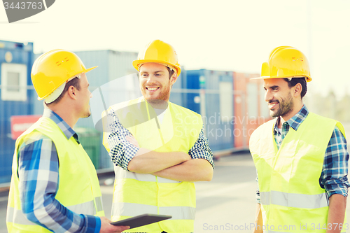 Image of smiling builders in hardhats with tablet pc