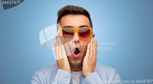 Image of face of scared man in shirt and sunglasses