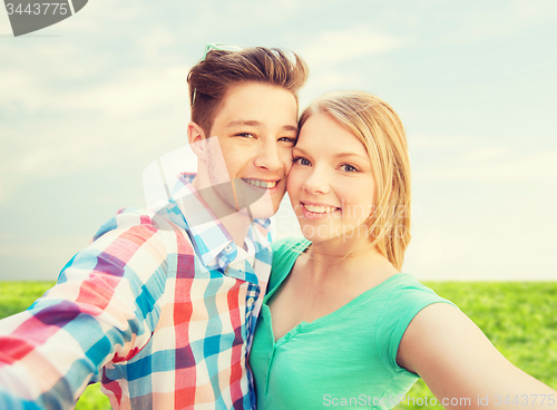 Image of smiling couple with smartphone in suburbs