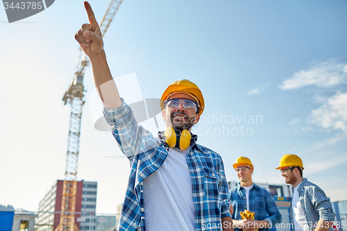 Image of builders pointing finger aside on construction