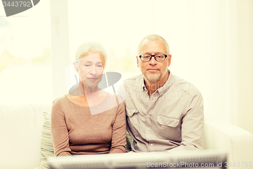 Image of senior couple watching tv at home