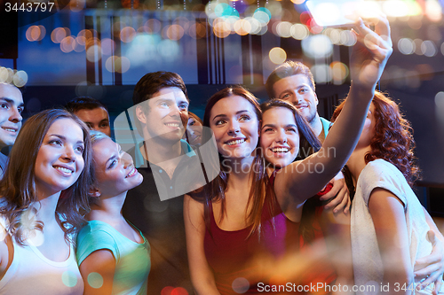 Image of friends with smartphone taking selfie in club