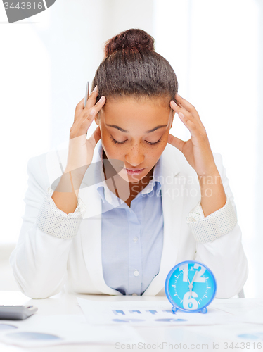 Image of businesswoman working with calculator in office