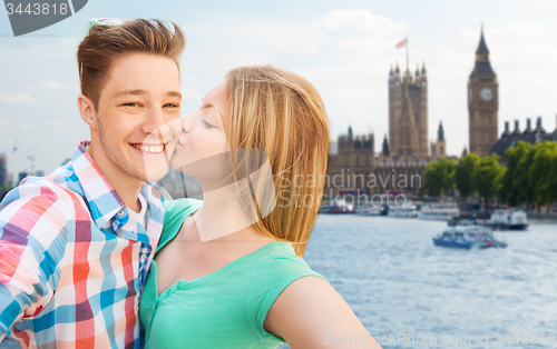 Image of happy couple taking selfie over london city